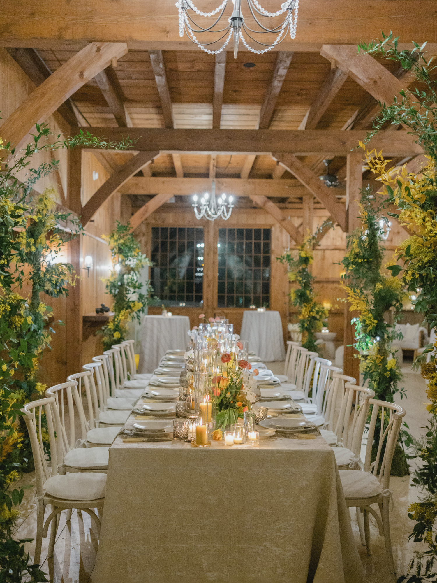 Wedding reception at Willow Hill in Connecticut with long banquet table, greenery, and candlelit décor by ONTHEMARC Catering