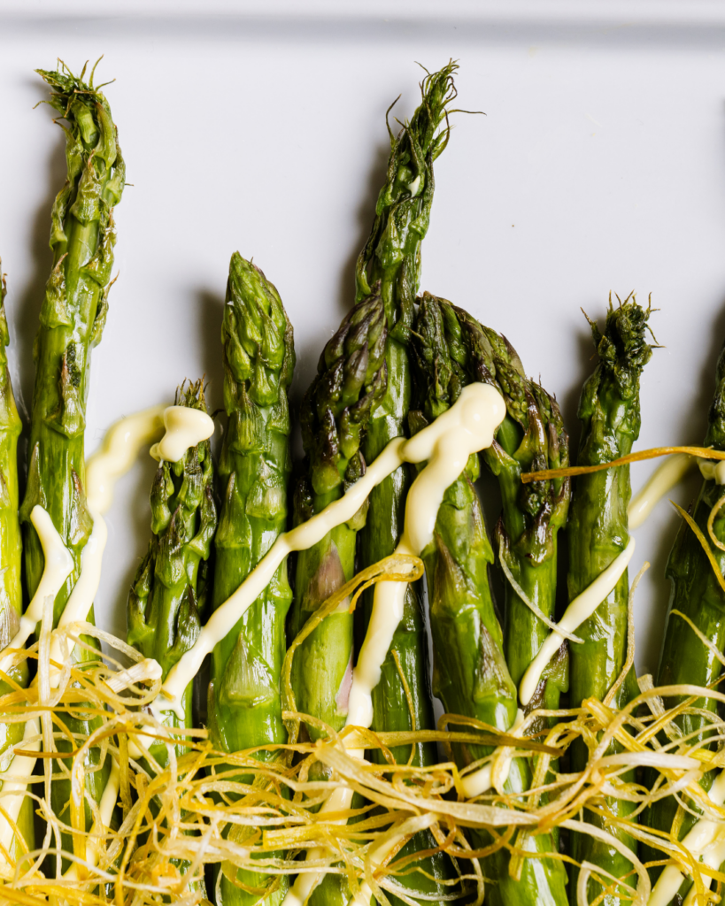 Grilled asparagus with citrus cream prepared by a full-service catering company.