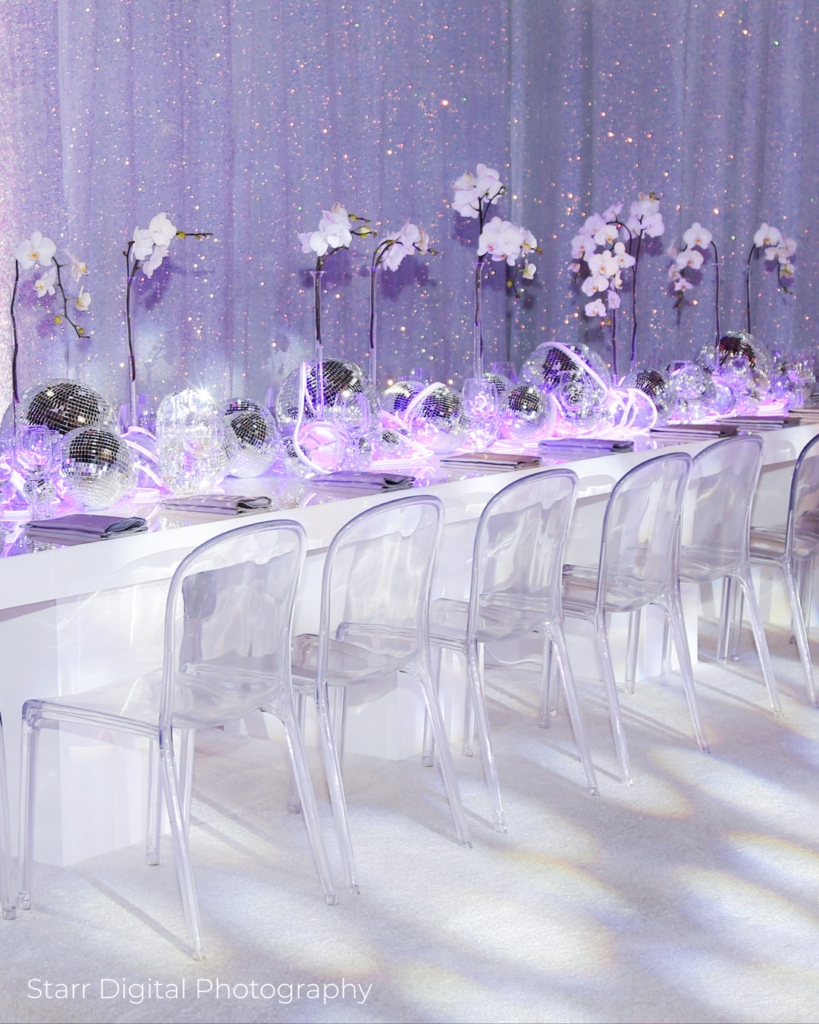 Modern Bat Mitzvah decor with disco balls, orchids, and clear ghost chairs at a Westchester event venue.